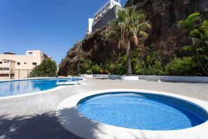 a large swimming pool next to a mountain at Ocean Panorama in Puntillo del Sol