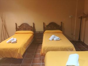 two beds in a room with yellow sheets and white towels at Complejo Rural Las Lomas de Biar in Biar +52 photos