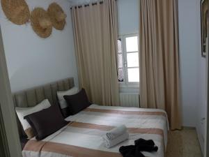 a bedroom with a bed with two towels on it at heart of marsa beach in Douar el Hafey