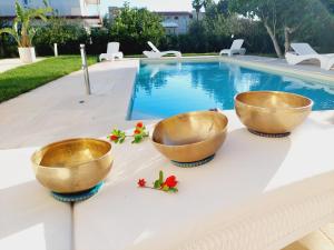 two bowls on a table next to a swimming pool at Dimora Gemella in Castellana Grotte