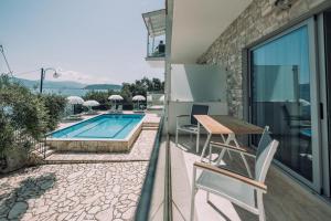 a patio with a table and chairs and a swimming pool at White House Apartment in Kalami