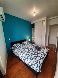 モントーバンにあるLe beau T3 Fonneuve clim parking facileの青い壁のベッドルーム1室