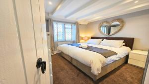 クロイドにあるDove Cott Croyde Sleeps 4 Central Locationの壁に鏡が付いた大きなベッドのある寝室