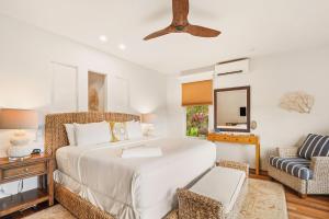 a bedroom with a large white bed and a chair at Kapiolani Villa home in Princeville