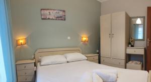 una camera da letto con un letto con due cuscini bianchi di Basilis room a Loutsa