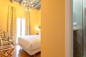 een slaapkamer met een bed en een kroonluchter bij Genteel Home Mateos Gago Terrace VI in Sevilla +19 foto's