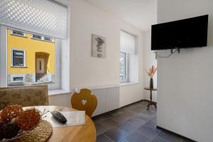 a living room with a table and a tv at Haus Berlin Annaberg in Annaberg-Buchholz