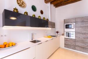 een keuken met witte kasten en een spoelbak bij Genteel Home Mateos Gago Terrace VI in Sevilla