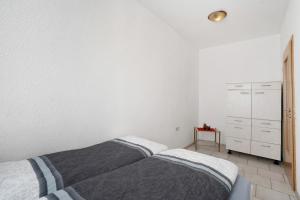 a white bedroom with a bed and a dresser at Haus Berlin Annaberg in Annaberg-Buchholz
