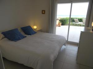 a bedroom with a bed with blue pillows and a balcony at Golf Mar II C B-3 in Pals +47 photos