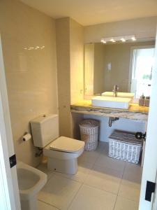 a bathroom with a toilet and a sink and a mirror at Golf Mar II C B-3 in Pals