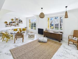 a living room with white walls and a table and chairs at Maison pour 8 - Piscine chauffée - 800m de la plage in Penmarcʼh