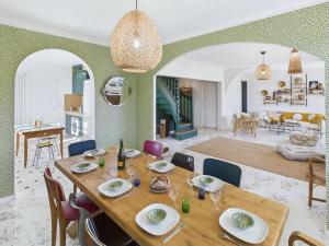 a dining room and living room with a table and chairs at Maison pour 8 - Piscine chauffée - 800m de la plage in Penmarcʼh