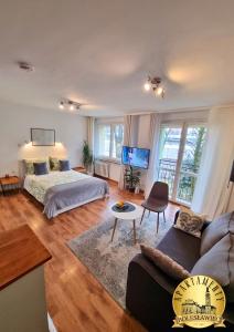 a living room with a bed and a couch at Apartamenty Bolesławiec Spółdzielcza Free parking in Bolesławiec