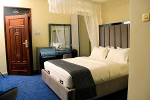 a bedroom with a large bed and a mirror at Solo Hites Hotel in Masaka