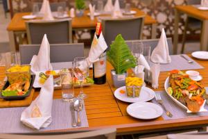 a table with plates of food and bottles of wine at Solo Hites Hotel in Masaka