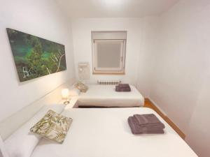 two beds in a room with white walls at En pleno centro del casco histórico de Hondarribia in Hondarribia