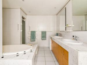 a white bathroom with two sinks and a tub at Ocean Edge Retreat in Knysna