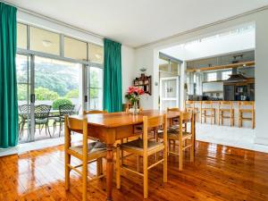 a dining room and kitchen with a wooden table and chairs at Ocean Edge Retreat in Knysna