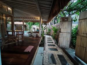 eine Veranda eines Hauses mit einem Tisch und Stühlen in der Unterkunft Villa Ibu gili trawangan in Gili Trawangan