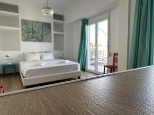 雅典6th Floor Skyline View Studio 2 in Athens的一间带床和大窗户的卧室