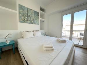 雅典6th Floor Skyline View Studio 2 in Athens的一间带大床和窗户的白色卧室