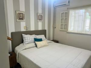 a bedroom with a white bed with pillows and a window at Casa de categoría para 6 personas in Santiago del Estero