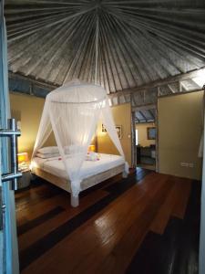 ein Schlafzimmer mit einem Bett mit Moskitonetz in der Unterkunft Villa Ibu gili trawangan in Gili Trawangan