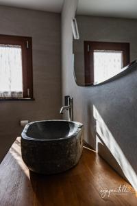 un bagno con un grande lavandino in pietra su un pavimento in legno di La Terrazza di Tranci a Calice al Cornoviglio