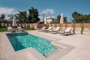 a swimming pool with lounge chairs and umbrellas at Villa Nicoldia with private pool near Laganas in Laganas