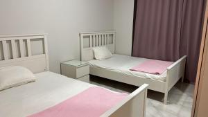two beds in a room with pink and white at exm55شاليه دايركت على الاجون مراسى الساحل chalet with perfect view lagoon marassi blanca in El Alamein