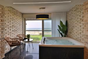 a large bath tub in a room with a table and chairs at שקיעה בים - דירות יוקרתיות מהממות עם ג'קוזי ונוף לים יש מקלט in Haifa