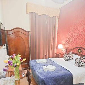 a bedroom with a bed and a vase of flowers on a table at Hotel Giubileo in Rome