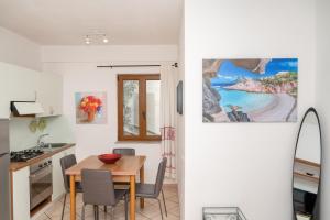 Guest House Via Acquedotto Romano في أولبيا: مطبخ وغرفة طعام مع طاولة وكراسي