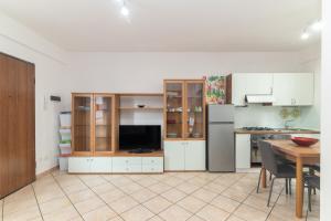 Guest House Via Acquedotto Romano في أولبيا: مطبخ بدولاب بيضاء وطاولة وثلاجة +14 صورة