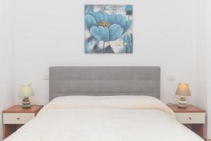 Guest House Via Acquedotto Romano في أولبيا: غرفة نوم بها سرير نفرين ومصباحين