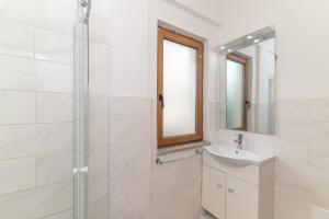 Guest House Via Acquedotto Romano في أولبيا: حمام أبيض مع حوض ودش