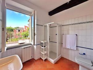 a bathroom with a shower and a sink and a window at La casa di Martina a San Pè in Castiglione Chiavarese
