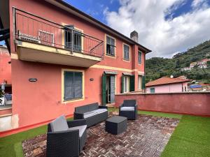 a house with a patio with chairs and a balcony at La casa di Martina a San Pè in Castiglione Chiavarese