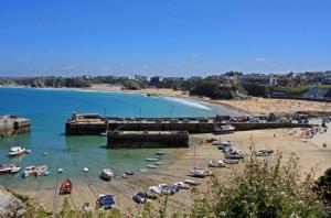 a beach with a bunch of boats in the water at Luxury 3-Bed house, Beach 300m, Sleeps 6, Parking in Newquay