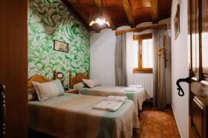 two beds in a room with green wallpaper at Casas Rurales Nerpio Villa Turrilla in Nerpio +291 photos