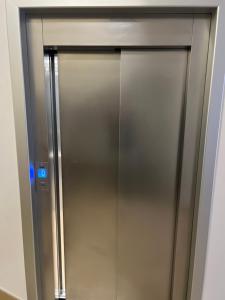 a stainless steel elevator door with a blue light at N&N Apartment in Čapljina