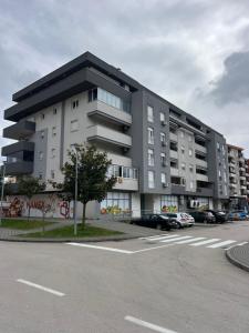 a large building with cars parked in a parking lot at N&N Apartment in Čapljina