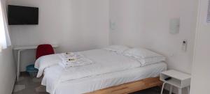 a small bedroom with a white bed with a red chair at CASA LUIGIA ROOMS MTB in FINALBORGO Bike room in Finale Ligure