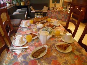 een tafel met borden met voedsel en sinaasappelsap bij Le Moulin d'eclaron in Éclaron
