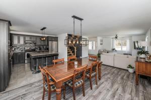 a kitchen and living room with a wooden table and chairs at Domaine à Blue in Baie-Saint-Paul +25 photos