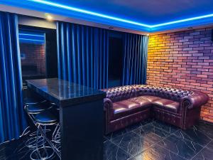 a bar with a leather couch and a bar stool at Apartament Red in Sarbinowo