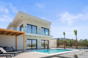 une maison avec une piscine devant dans l'établissement Aetheria & Aura Suites by Temma Villas, à Chersónissos