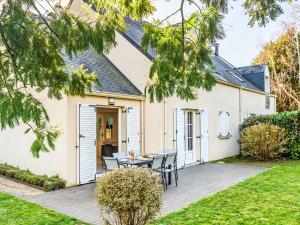 a patio with a table and chairs in front of a house at Holiday Home Ar Mimoza by Interhome in Le Bono