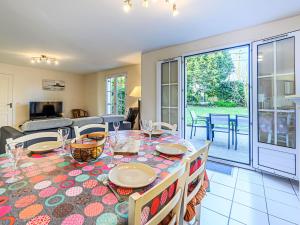 a dining room and living room with a table and chairs at Holiday Home Ar Mimoza by Interhome in Le Bono